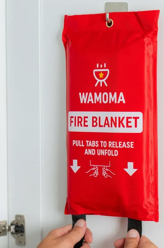 The Wamoma Fire Blanket case hanging on a cabinet door